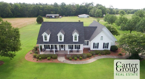 A white house on green acreage