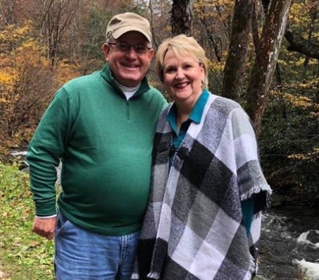 Coggins and his wife posing outdoors