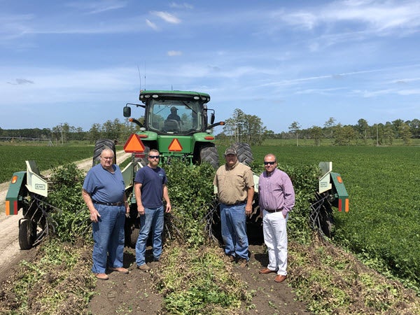 Men standing by tractor