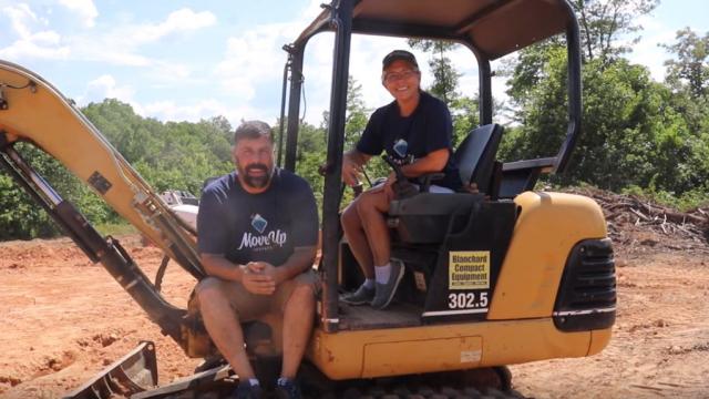 Ken and LeighAnn sitting on a large piece of digging equipment