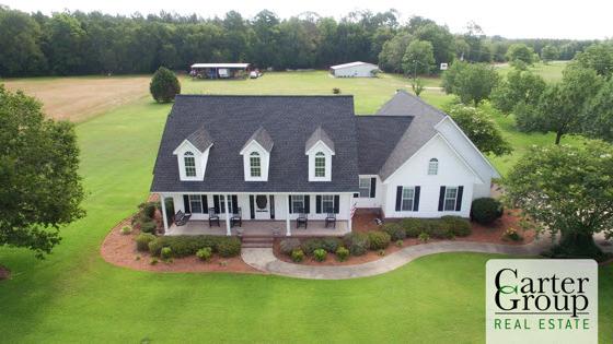 A white house on green acreage