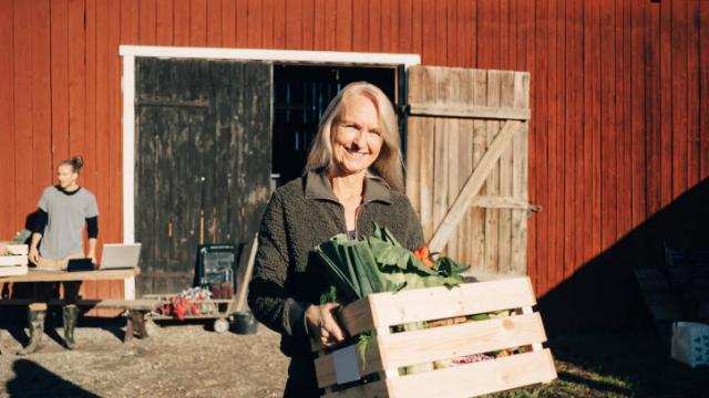 Woman smiling carrying veggie basket