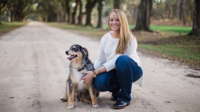Sara Lovelace with a cattle dog on a dirt road