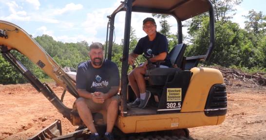 Ken and LeighAnn sitting on a large piece of digging equipment