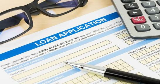 Loan application, pen, glasses, and calculator